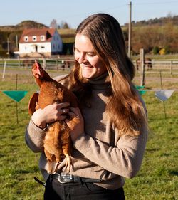 Frau mit einem Huhn in der Hand