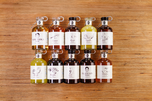 KI generiert: Eine Sammlung von kleinen Flaschen mit verschiedenen Spirituosen auf Holzuntergrund. Texte: "PEPE VODKA", "ELLEN GIN".