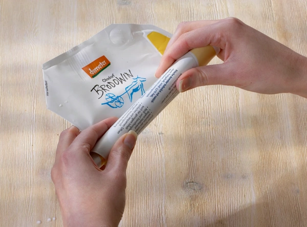 KI generiert: Zwei Hände halten eine Verpackung mit der Aufschrift "demeter Biohof Brodowin".