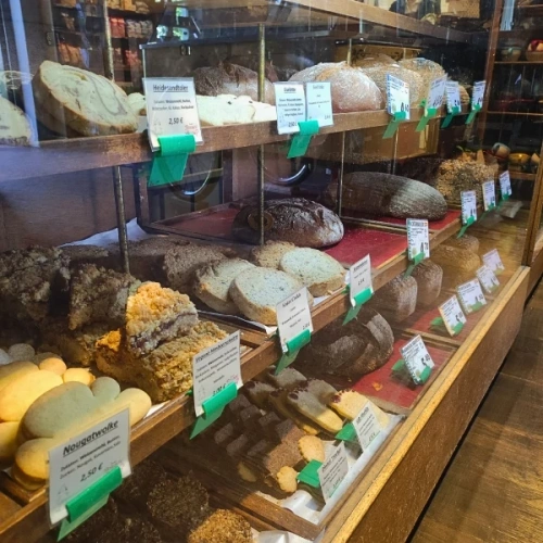 KI generiert: Das Bild zeigt einen Geschenkkorb mit einer Vielzahl von Bio- und Feinkostlebensmitteln, darunter Kaffee, Saft, Schokolade und Gewürze. Die Produkte sind ansprechend in einem Karton arrangiert.