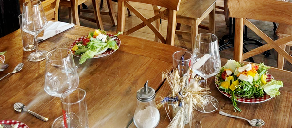 KI generiert: Ein gedeckter Tisch mit leeren Weingläsern und kleinen Salattellern.