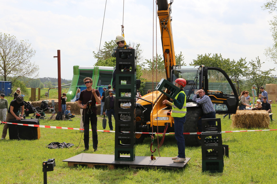 KI generiert: Ein Mann klettert auf gestapelte Getränkekisten bei einem Outdoor-Event.
