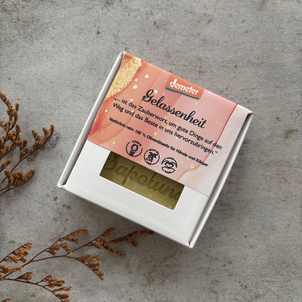 KI generiert: Packung Olivenseife mit dem Text: "Gelassenheit ist das Zauberwort, um gute Dinge..." von Demeter.