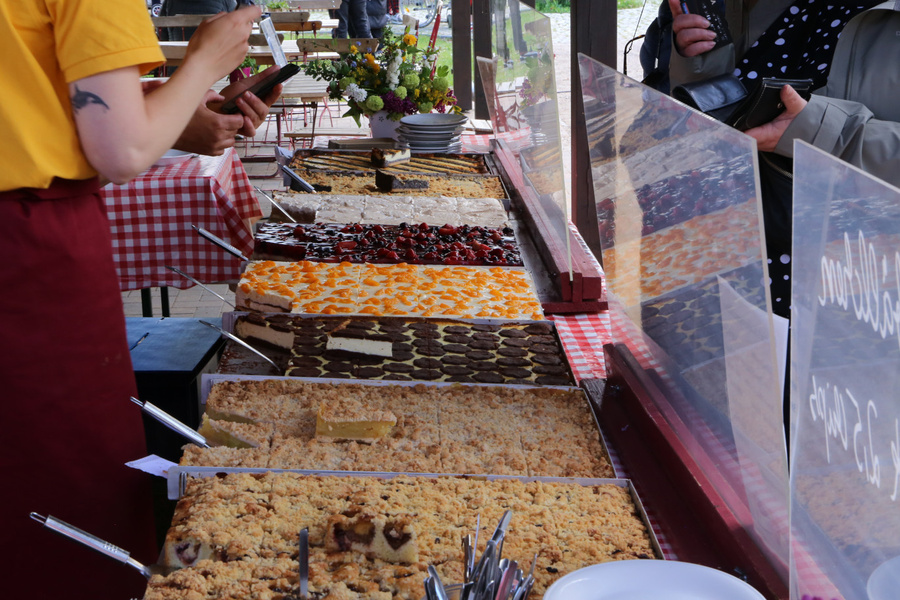 KI generiert: Ein Marktstand mit einer großen Auswahl an verschiedenen Kuchen.