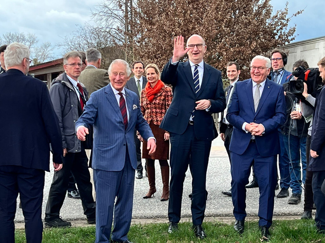 KI generiert: Mehrere gut gekleidete Personen posieren lächelnd im Freien für ein Gruppenfoto.