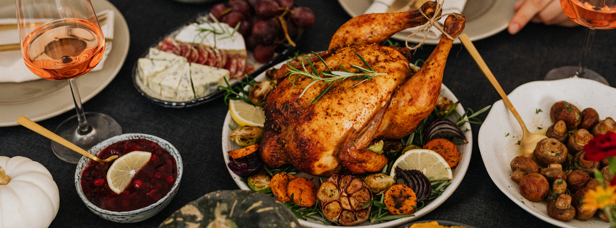 KI generiert: Festliches Essen mit gebratenem Huhn, Beilagen und Getränken auf einem gedeckten Tisch.